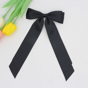 Gros plan d'un nœud en satin noir élégant avec de longs rubans et une texture lisse