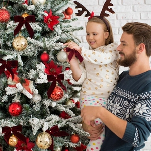 Vue détaillée de nœuds de Noël en velours rouge avec crochets sur un sapin décoré