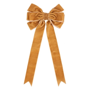 Close-up of mustard yellow velvet Christmas tree bow with layered texture and long streamers