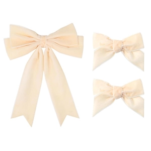 Gros plan de trois nœuds à cheveux en velours beige avec liseré blanc sur fond blanc