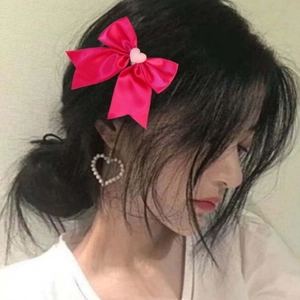 Barrette à cheveux nœud rose avec détail cœur portée par un modèle pour un look doux