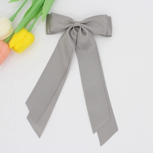 Détail du nœud papillon en satin gris foncé avec de longs rubans élégants pour cheveux
