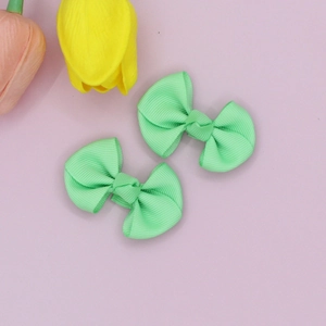 Close-up of mint green grosgrain ribbon hair bows with soft ribbed fabric texture