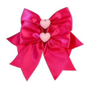 Détail de nœuds en ruban de satin rose avec centres de cœur mats pour cheveux