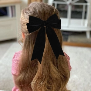 Barrette à cheveux avec grand nœud en velours noir et rubans longs sur cheveux bruns