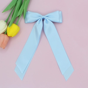 Détail d'un nœud papillon en satin bleu clair avec de longs rubans à l'aspect soyeux