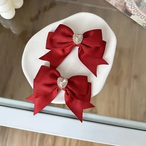 Detailansicht der roten Satin-Haarschleifen mit herzförmigem Diamantschmuck