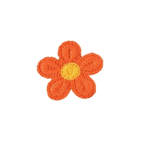 Detail of embroidered flower hair clip featuring orange petals and yellow center
