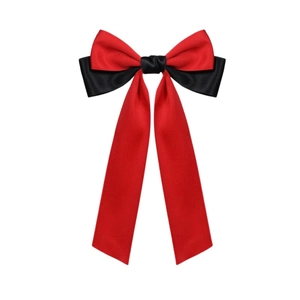 Detail showing the red and black satin bow hair clip with elegant long ribbon streamers