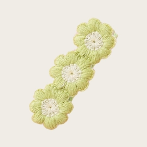 Vue détaillée de la barrette à fleurs brodée à la main en vert tendre et blanc crème