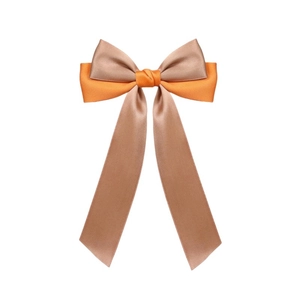 Detail view of the elegant satin dual-tone bow hair clip with long champagne ribbons