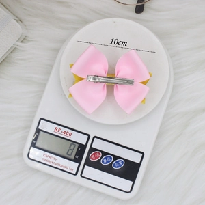 Barrette nœud rose à paillettes pour filles avec ruban gros-grain sur balance blanche