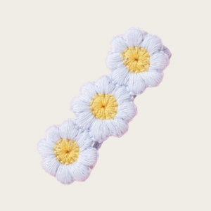 Détail de la barrette marguerite brodée à la main avec pétales bleus et texture fine
