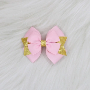 Détail du nœud papillon rose en gros-grain à deux couches avec des paillettes dorées