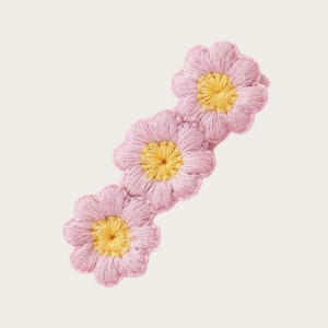 Gros plan de pinces à cheveux marguerites brodées rose et jaune avec détails floraux 3D