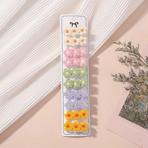 Détail du lot de 10 barrettes à fleurs brodées aux tons pastel sur carte de support