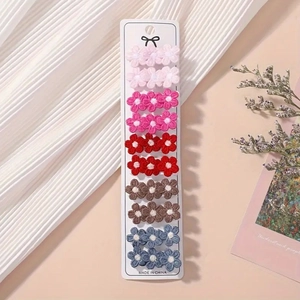 Vue détaillée de 10 barrettes à fleurs brodées présentées sur une carte en papier