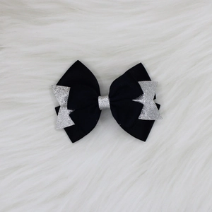 Détail du nœud papillon en ruban gros-grain noir avec sequins argentés sur fourrure
