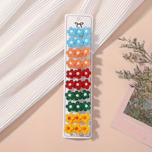 Vue détaillée de 10 paires de pinces à cheveux à fleurs brodées sur des cartes blanches