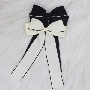 Detail of elegant bow hair clips with long ribbons on soft white plush background
