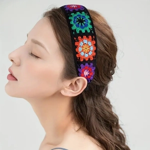Detail of bohemian hand-knitted floral headband featuring colorful crochet grandma squares
