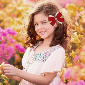 Dettaglio di un fiocco per capelli con paillettes rosse e bianche su una bambina