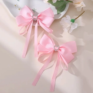 Détail de nœuds à cheveux roses avec centre en cristal et longs rubans élégants