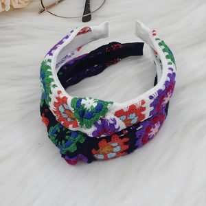 Close-up of bohemian knit headbands with colorful floral patterns and knot detail