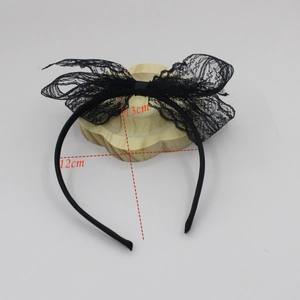 Detalle de la diadema con lazo de encaje negro con medidas marcadas de 12 cm por 13 cm de alto