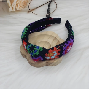 Close-up of bohemian hand-knitted floral headband with colorful vintage crochet patterns