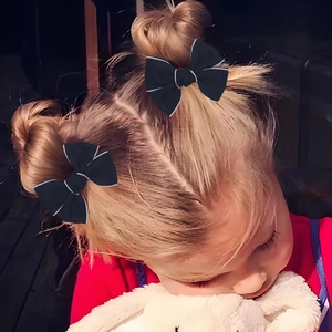 Vue détaillée de deux nœuds papillon en jacquard noir avec surpiqûres sur cheveux blonds