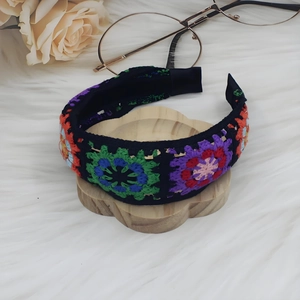 Detail of bohemian hand-knitted floral headband with colorful crochet granny squares