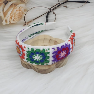 Close-up of handmade crochet granny square headband with colorful floral knit pattern