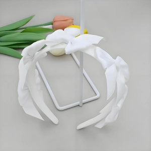 Detailed view of white headband featuring multiple soft fabric bows in sweet princess style
