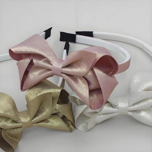 Set di tre cerchietti con grandi fiocchi metallici nei colori rosa, oro e argento