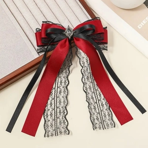 Detail of red satin and black lace bow hair clip with vintage oval grey gemstone