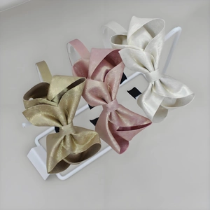 Set di tre eleganti cerchietti con fiocco dorato nei colori champagne, rosa e bianco perla