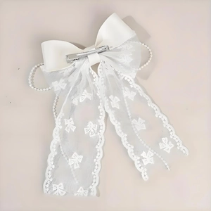 Elegant white lace bow hair clip with pearls and ribbon on a clean background
