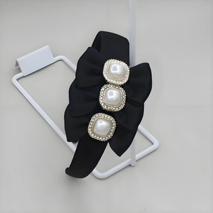 Detail of black velvet headband with oversized bow and three square pearl rhinestone pins