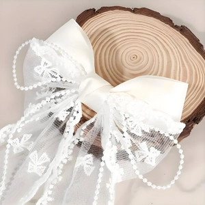 Elegant white lace bow hair clip with pearls and ribbon for a sweet bridal look