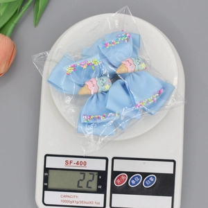 Lot de quatre barrettes à cheveux nœud glace bleu clair avec décors de macaron