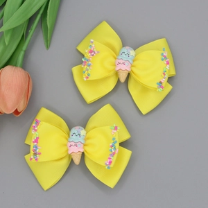 Détail de barrettes à ruban jaune avec crème glacée de dessin animé et paillettes sucrées