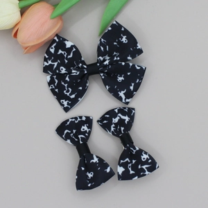 Princess style cow print bow hair clip set with three pieces on gray background