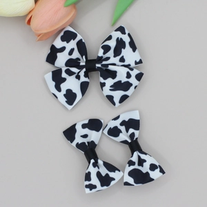 Detail of cow pattern bow hair clips set on high-quality ribbed fabric for girls