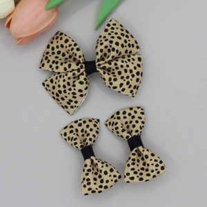 Macro detail of three-piece set leopard print hair clips with elegant black ribbon center