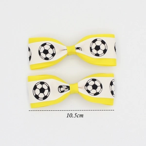 Detail showing 10.5cm soccer pattern bow hair clips with yellow and white ribbons