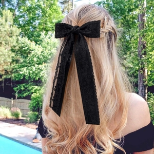 Elegant large black lace double bow hair clip with long streamers on blonde model
