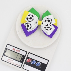 Weight measurement of Brazilian Carnival bow hair clip with soccer pattern on scale