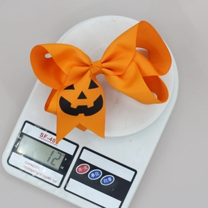Détail d'un nœud papillon orange pour Halloween avec motif citrouille pesant 12 grammes