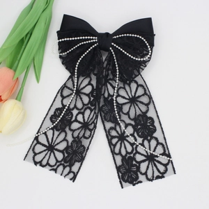 Elegant black lace bow hair clip with pearls and floral embroidery on white background